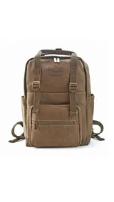 Mochila urbana de tela canvas color marrón, con diseño funcional que incluye compartimento para notebook de 15 pulgadas y espacio interior organizado para set de mate. Cuenta con correas ajustables, manija superior reforzada, bolsillo frontal con cierre y detalles en cuero sintético.