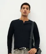Remera de manga larga con textura tipo waffle, cuello redondo con tapeta de botones y corte ajustado al cuerpo.