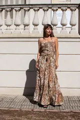 Vestido largo de silueta fluida con estampado animal print en tonos tierra. Presenta un top fruncido con tiras finas, espalda descubierta y falda amplia con volado en el ruedo.