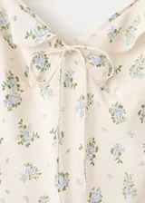 Vestido midi de viscosa color beige con estampado de flores azules, escote en V con volantes y tirantes finos ajustables.