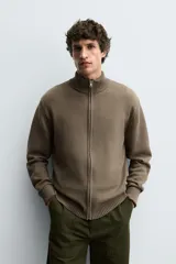 Chaqueta de punto de algodón con corte regular, cuello perkins y cierre frontal con cremallera. Presenta mangas largas con puños acanalados y terminaciones en rib.