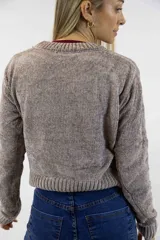 Buzo tejido de chenille blanco con cuello redondo, mangas largas, terminaciones acanaladas y diseño frontal con detalles de trenzas y texturas combinadas.