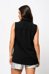 Camisa negra sin mangas con cuello mao adornado con un delicado volado y cierre frontal con botones.