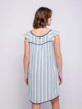 Vestido corto de viscosa con estampado a rayas verticales en tonos celeste, azul y blanco. Sin mangas, con volados en los hombros y escote cuadrado con ribete azul marino.