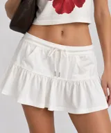 Falda corta blanca con cordón ajustable en la cintura y volados en el borde inferior.