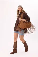 Bolso estilo hobo de símil gamuza color marrón, con diseño amplio y detalle de flecos largos en todo el contorno y las correas.