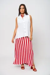 Camisa blanca sin mangas con cuello mao adornado con un delicado volado y cierre frontal con botones.