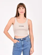 Musculosa de tejido acanalado color beige, con escote redondo y estampado frontal con la frase 'LESS IS MORE' en color negro.