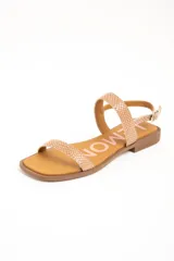 Sandalias planas de cuero color beige con estampado tipo animal print de serpiente texturado. Posee una tira delgada en la parte delantera y una tira ajustable con hebilla metálica alrededor del tobillo, sobre una suela plana y punta cuadrada.