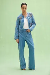Pantalon de denim azul con corte recto y amplio, decorado con aplicaciones de pedrería formando un patrón de rombos en los laterales.