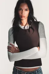 Camiseta de manga larga con diseño de capas superpuestas que crea un efecto triple. Presenta cuello redondo, corte ajustado y combinación de colores en tonos blanco, gris y negro.