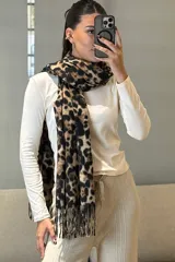 Bufanda rectangular con estampado animal print de leopardo en tonos marrones y negros, con terminación de flecos en los extremos.