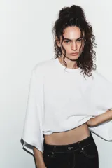 Camiseta de algodón con corte holgado, cuello redondo y mangas anchas tipo capa.