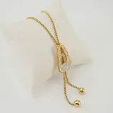 Collar estilo lariat de acero quirúrgico con baño de oro 18k, con dije triangular decorado con circonias y terminales de bolitas doradas.