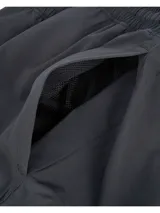 Pantalón cargo Under Armour Woven para hombre, color negro, de corte ajustado con bolsillos laterales y logo de la marca en la pierna izquierda.