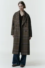 Abrigo largo de corte oversize con estampado de cuadros en tonos marrones y líneas azules. Presenta cuello de solapa, cierre frontal cruzado con botones, mangas largas y bolsillos delanteros con solapa.