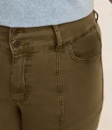 Pantalón flare de sarga color verde oliva, con cintura ancha, doble botón, cierre tradicional, trabillas, detalle de recortes y bolsillos.