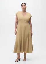 Vestido midi de corte evasé con cuello en pico y manga corta. Presenta un diseño con costuras verticales decorativas y cierre de cremallera en la parte posterior.