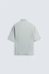 Camisa de manga corta con cuello solapa, confeccionada en tejido de mezcla de lyocell con textura de efecto arrugado y cierre frontal de botones.