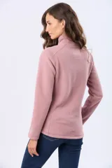 Buzo de polar color crema con cuello alto y cierre frontal parcial. Presenta detalles en cuero en el tirador del cierre y un pequeño bordado en el pecho y en la manga.