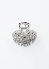 Broche de pelo metálico plateado con forma de corazón y diseño calado.