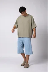 Remera de corte oversize confeccionada en tejido texturado tipo lino, de color beige, con cuello redondo amplio y mangas cortas de calce relajado.