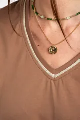 Remera de algodón peinado color marfil, de manga corta y corte al cuerpo, con escote en V ribeteado con hilo dorado.