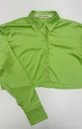 Camisa crop de seda brillante color verde neón, con cuello clásico, cierre frontal de botones y mangas largas con puños.