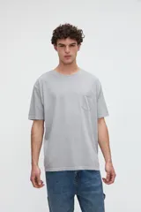 Remera de manga corta color gris con efecto lavado, cuello redondo y un bolsillo aplicado en el pecho. Presenta calce relaxed y diseño estampado en la espalda.