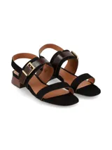 Sandalia de cuero nobuk negro con taco bajo efecto madera, tira delantera fina, tira ancha en el empeine con hebilla metálica dorada y aplique de cuero con textura croco, y tira ajustable al talón.