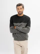 Buzo de felpa de diseño colorblock con corte clásico, cuello redondo, mangas largas y puños de canalé. Combina la parte superior en negro con la parte inferior y las mangas en gris.