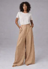 Pantalón de tiro alto con corte relajado y pierna ancha. Confeccionado en lino, presenta pretina con presillas, cierre frontal con botón y tablas delanteras que aportan estructura.