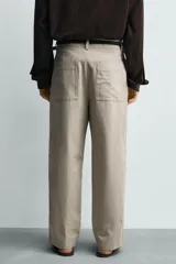 Pantalón relaxed fit para hombre, confeccionado en tejido con mezcla de algodón y lino, en color beige. Presenta bolsillos laterales, bolsillos traseros de plastrón y cierre frontal con cremallera y botón.