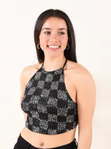 Top corto negro con diseño de cuello halter y estampado de cuadros de lentejuelas plateadas y negras.