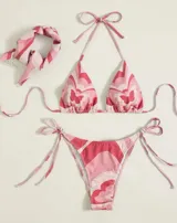 Conjunto de bikini de tres piezas con estampado de mariposas en tonos rosados y blancos. Incluye top triangular, tanga con tiras laterales y pañuelo para la cabeza.
