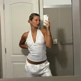 Top blanco con escote halter y apliques metálicos plateados.