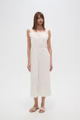 Mono de algodón blanco con bordado broderie, cuello cuadrado y volados en los breteles. Presenta un diseño entallado en el torso y pantalones de pierna ancha.