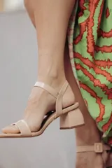 Sandalias plateadas con tira ancha sobre los dedos, tira fina con hebilla al tobillo y taco cuadrado bajo.