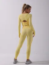 Conjunto deportivo amarillo compuesto por remera de manga larga con abertura en la espalda y calzas largas.