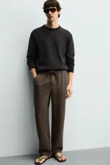 Pantalón de corte regular fit confeccionado en tejido mezcla de algodón, con cintura elástica ajustable mediante cordón, bolsillos laterales y bolsillos traseros de vivo.