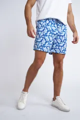 Short de baño con cintura elástica y cordón ajustable, confeccionado en tela ligera de secado rápido. Presenta un estampado botánico integral en tonos amarillos, blancos y azules, con dos bolsillos delanteros y uno posterior.