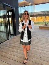 Chaleco de cuero marrón con detalle de tachas en el contorno.