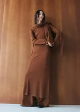 Vestido midi de punto color marrón, de corte recto y ajustado, con mangas largas y cuello bote. Incluye una bufanda integrada del mismo tejido.