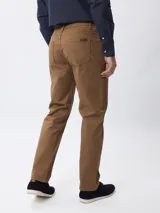 Pantalón de corte recto en color tostado, confeccionado en tejido de algodón con elastano. Presenta cierre frontal con botón y cremallera, además de bolsillos laterales y traseros.