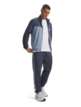 Conjunto deportivo Under Armour compuesto por una campera de cierre frontal con cuello alto en tonos azul marino y celeste, y un pantalón largo en color azul marino con franjas laterales celestes.
