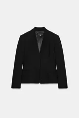 Blazer entallado negro con cuello sin solapa, manga larga y bolsillos de vivo en el delantero. Cuenta con cierre frontal con botón a presión oculto.
