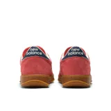 Championes New Balance T500, color rosado con la tradicional 'N' en blanco, detalles en azul marino en el talón y suela de goma color caramelo. Confeccionados en gamuza y nobuk, con puntera perforada.