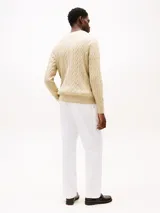 Sweater Tommy Hilfiger de punto trenzado color beige, con cuello redondo, mangas largas y puños y bajo de canalé. Incluye logo bordado en el pecho.
