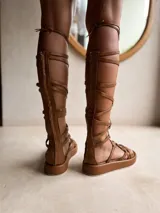 Sandalias gladiadoras negras con plataforma, tiras de cuero y cierre con cordones.