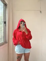 Buzo rojo de plush con capucha, bolsillo, cuello con cierre y elástico ajustable en el ruedo.